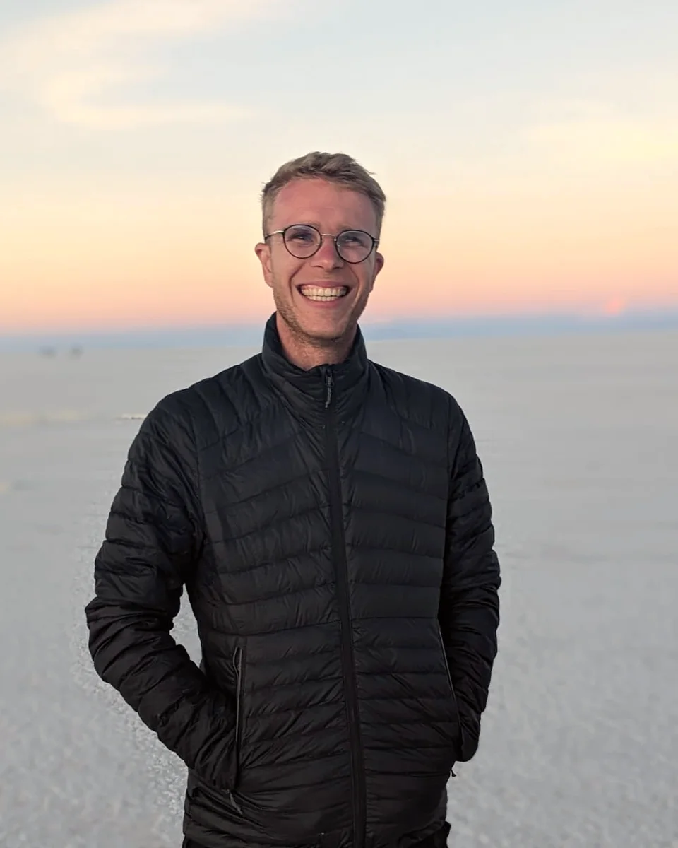 Portrait de Lucas Zehner, souriant, sur un désert de sel au coucher du soleil